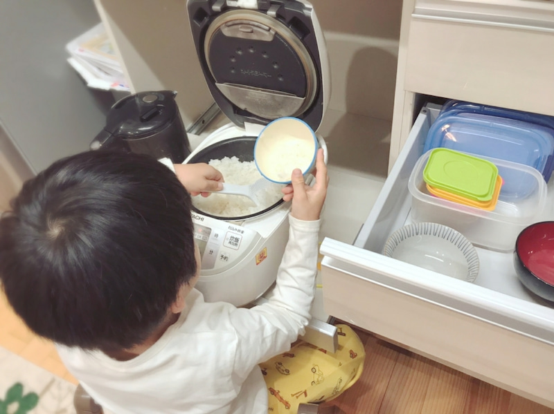 子どもがごはんをよそるお手伝い